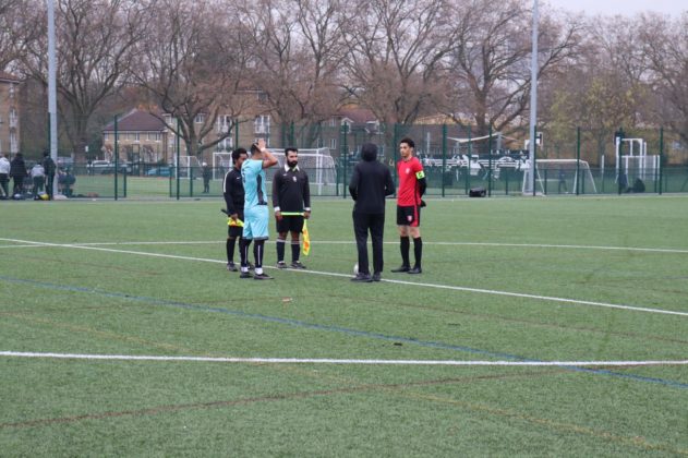 Captains from either side join the referee and linesman for the coin flip at the start of the game.