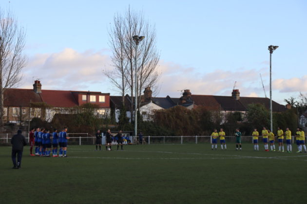 Two football teams in the centre of the pitch applauding