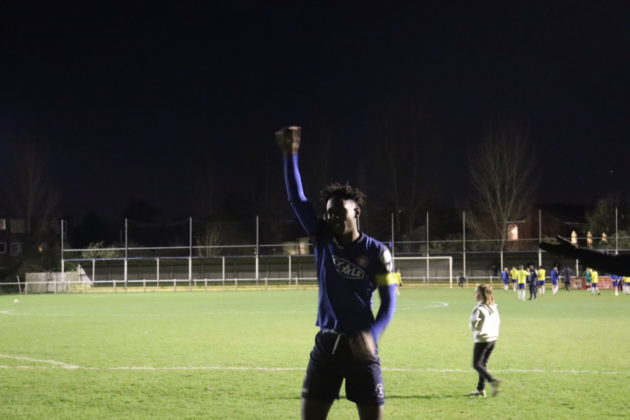 A footballer celebrates victory after the final whistle